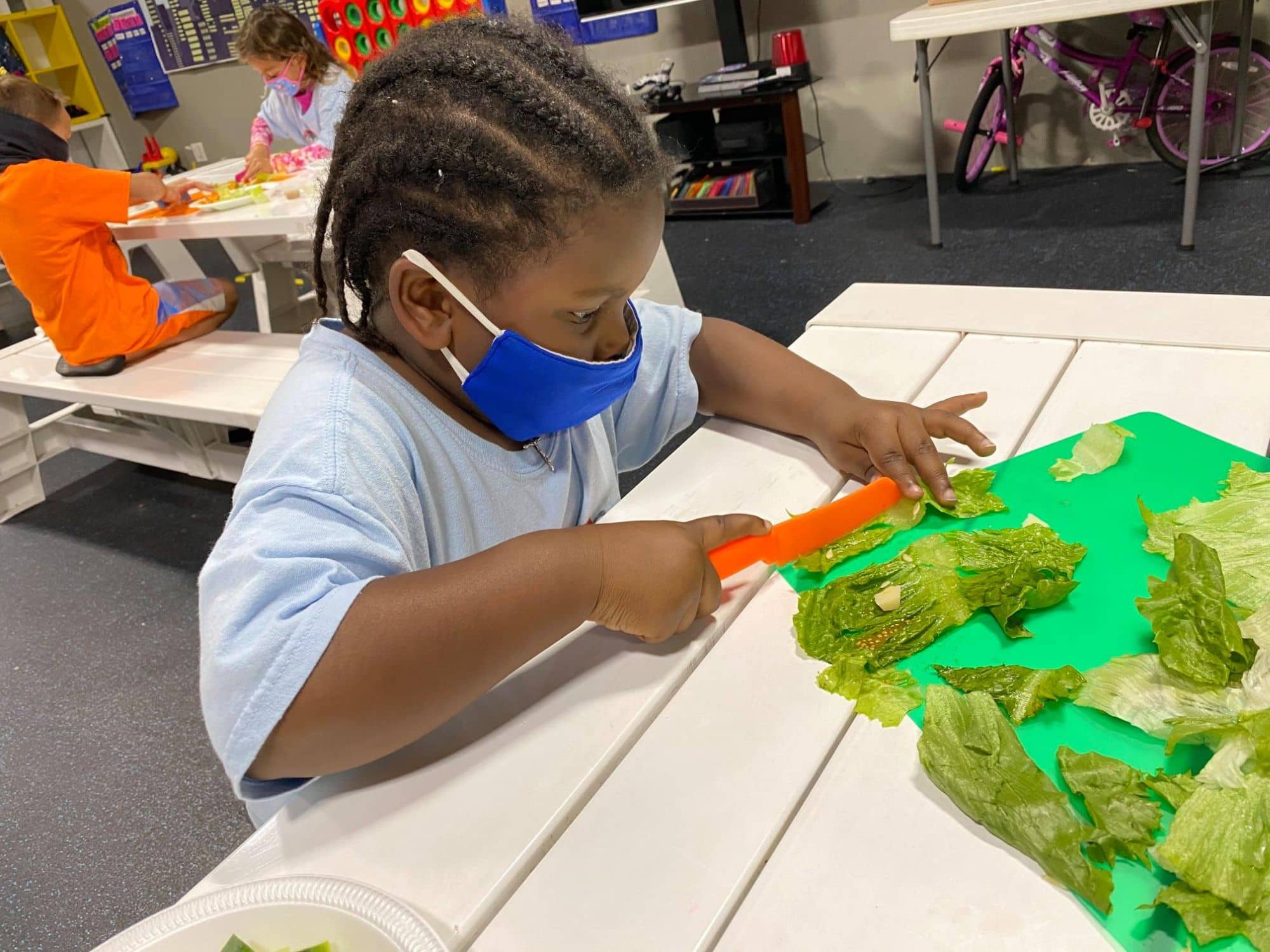 Child preparing salad